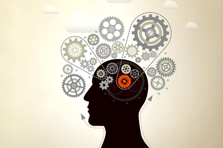 Silhouette head profile with cogs (one orange) inside brain and outside top of head on gold background with clouds