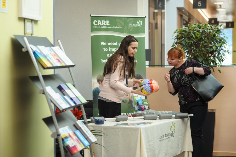Researcher showing a model brain to a visitor