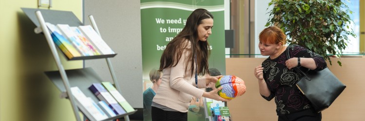 Researcher showing a model brain to a visitor