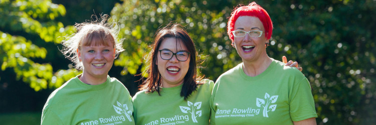 3 supporters smiling at the camera wearing green Anne Rowling Clinic T-shirts