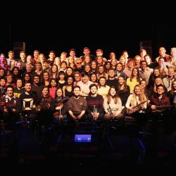 The cast of medics musical all sat on a stage