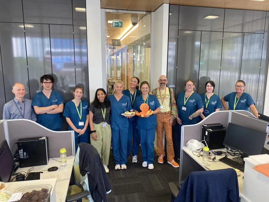 The MS research team celebrating the 40th participant to be randomised to the Octopus clinical trial. One of the team members is holding a plush toy orange Octopus.