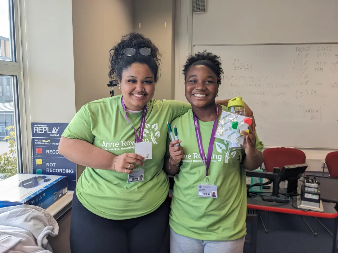 Two of the Edinburgh BioQuarter School Interns wearing Anne Rowling Clinic t-shirts and holding branded merchandise